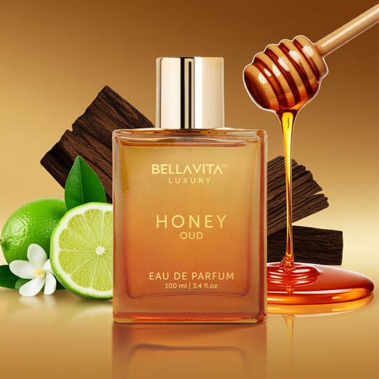 Bellavita Luxury Honey Oud eau de parfum bottle with honey, lime, and wood elements on a reflective surface.
